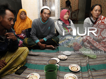 Residents of Sumbersari village gather at their relative's house in Supiturang village on December 2, 2020, after being evacuated due to the...