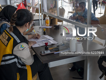 Officers validate the administration of travelers at Mutiara Sis Aljufri Airport, Palu, Central Sulawesi Province, Indonesia on December 1,...