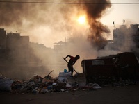 A labour works at a garbage area as fire creates toxic smoke at Keraniganj area in Dhaka, Bangladesh on Thursday, December 03, 2020. (