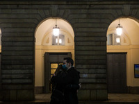 A couple kisses in front of the Teatro alla Scala in Christmas atmosphere in Milan during coronavirus emergency, Milan, Italy, on December 0...