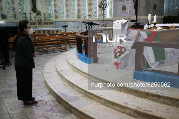 A man kneels near the coffin of late Algerian Archbishop Henri Teissier on December 9, 2020 before a mass in his honour in Algiers on the ev...