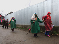 Kashmiri women walk near the gun-battle site in Tiken village of Pulwama Kashmir on December 09, 2020.Three militants were killed and a civi...