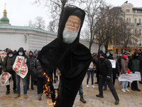 Protestors burn an effigy depicting the Ecumenical Patriarch of Constantinople Bartholomew I  during their protest in Kyiv, Ukraine on 11 De...