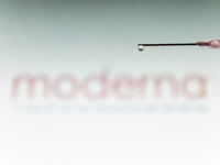 Photo illustration of a medical syringe with a needle seen in front of the Moderna pharmaceutical corporation logo. Moderna expects the Amer...
