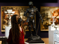 A member of staff wearing a face mask poses with a bronze figure of St George, by British sculptor Alfred Gilbert, estimated at 80-000-120,0...