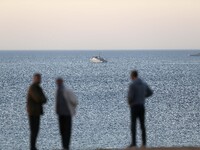 A warship and rescue boats arrive at the scene of a helicopter crash in the Mediterranean Sea off the commune of Bouharoun in the province o...