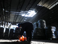 A Palestinian man inspects a partially destroyed soft drink factory following Israeli airstrikes on Gaza City, Saturday, on December 26, 202...