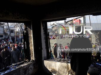 Kashmiri people stand around a damaged residential house in Kanigam Village of Shopian district, South of Srinagar, Indian Administered Kash...