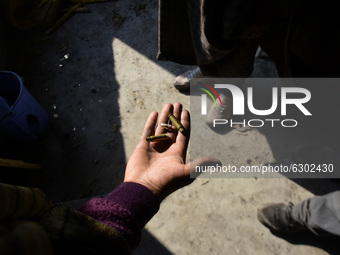 A Kashmiri man shows the bullet cartridges inside a damaged residential house in Kanigam Village of Shopian district, South of Srinagar, Ind...