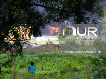 A man is seen looking at a  burning fuel terminal. Fuel storage terminal is burning near Kiev, June 9, 2015. (