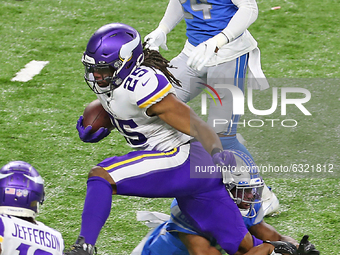 Minnesota Vikings running back Alexander Mattison (25) carries the ball while Detroit Lions strong safety Duron Harmon (26) attempts to pull...