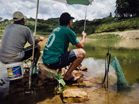 FILE - Feb 14th 2015 - Villagers fish near to water pumps in the Atibainha dam, in Atibaia, around 60 km northeast of São Paulo. To get the...