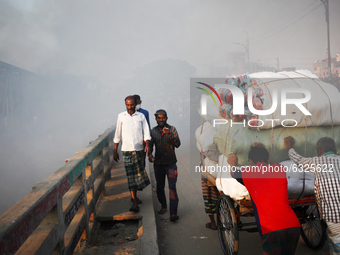 Pedestrians walk through toxic smoke at Keraniganj area in Dhaka, Bangladesh on Wednesday , January 06, 2021. (