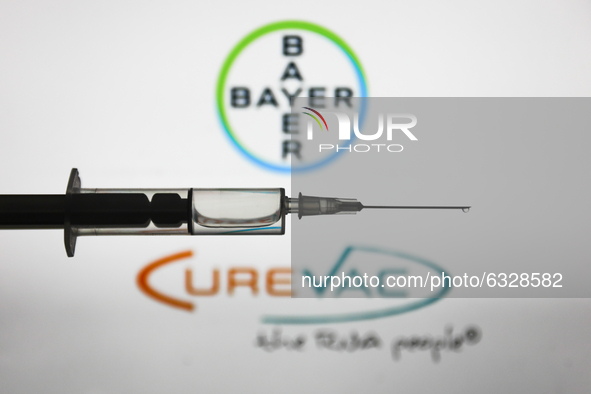Medical syringe is seen with Bayer and CureVac logos displayed in the background in this illustration photo taken in Poland on January 7, 20...