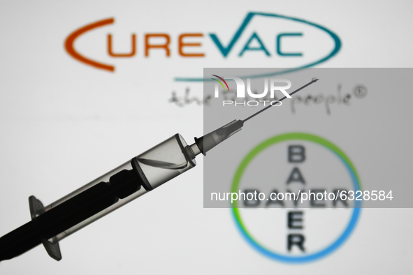 Medical syringe is seen with Bayer and CureVac logos displayed in the background in this illustration photo taken in Poland on January 7, 20...