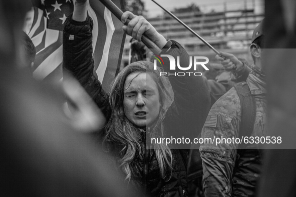 (EDITOR'S NOTE: Image was converted to black and white) A Trump supporters waves an american flag as their eyes sting near the U.S. Capitol...