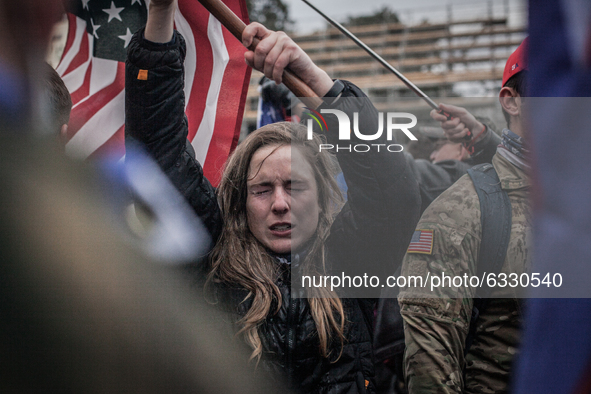 A Trump supporters waves an american flag as their eyes sting near the U.S. Capitol on January 06, 2021 in Washington, DC. The protesters st...