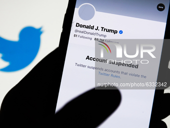 Donald Trump's Twitter account displayed on a phone screen and Twitter logo in the background are seen in this illustration photo taken in P...