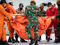 Millitary and Indonesia searcha nd rescue moving bodies and debris to open location at the harbour. Cooperative rescue from Indonesia Millit...