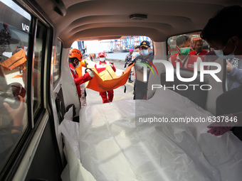 Officers lift the bag containing human remains of Sriwijaya Air passengers to the ambulance and will be taken to the National Police Hospita...