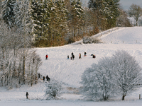people walks on a snow covered field during the winter season in Tondorf during the hard lock down most ski resorts are closed down (
