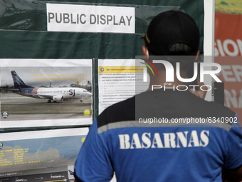 Personnels of Indonesian Search And Rescue Agency pay attention to the information board regarding the Sriwijaya Air Boeing 737-500 accident...