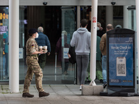 A military personnel carries take away coffee outside NHS Nightingale hospital at the ExCeL exhibition centre, which re-opens today as a mas...