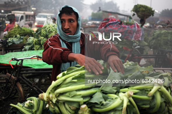 A local vendor collects vegetable from a wholesale vegetable market in a early morning in Dhaka, Bangladesh on Tuesday, January 12, 2020.  