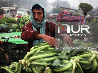 A local vendor collects vegetable from a wholesale vegetable market in a early morning in Dhaka, Bangladesh on Tuesday, January 12, 2020.  (