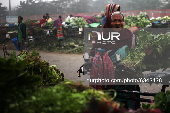An elderly women reacts to the camera as she came to sale her goods in a wholesale vegetable market in Dhaka, Bangladesh on Tuesday, January...