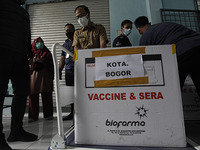 Workers carry transport boxes of the Sinovac Biotech Ltd. COVID-19 vaccine in Bogor, West Java, Indonesia, on January 12, 2021. President Jo...