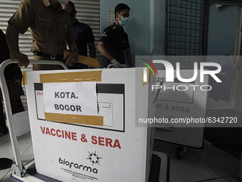 Workers carry transport boxes of the Sinovac Biotech Ltd. COVID-19 vaccine in Bogor, West Java, Indonesia, on January 12, 2021. President Jo...