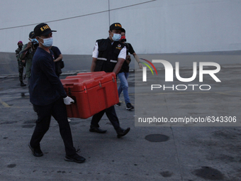 Indonesian National Safety Transportation Commite personnels carries the box containing the Flight Data Recorder (FDR) of crashed Sriwijaya...