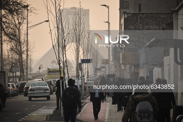 Iranian people walk along a street-side in western Tehran during a polluted air, following the COVID-19 outbreak in Iran, on January 12, 202...