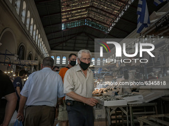 Daily life scene in the Varvakios central fish market in downtown Athens on October 11. People are seen wearing face masks and face shields...
