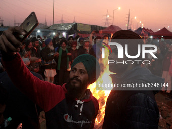 Protesting farmers celebrate Lohri festival around a bonfire, as they block a major highway in protest against new farm laws at the Delhi-Ut...