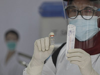 A health worker poses with a vial containing a vaccine Sinovac for the COVID-19 coronavirus at the health office in Bogor, West Java, Indone...