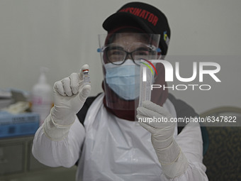 A health worker poses with a vial containing a vaccine Sinovac for the COVID-19 coronavirus at the health office in Bogor, West Java, Indone...