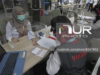 A health worker gets her checked a blood pressure before receives a dose of the Sinovac Biotech Ltd. coronavirus vaccine at the health offic...