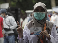 A healthcare worker poses with vaccination card  at the health office in Bogor, West Java, Indonesia on January 14, 2021. Indonesia starts t...