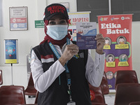 A healthcare worker displays her COVID-19 vaccination record card after receiving the Sinovac vaccine at the health office in Bogor, West Ja...