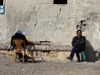 Palestinian refugees sit outside their home in the al-Shati refugee camp in Gaza City, on January 14, 2021. (