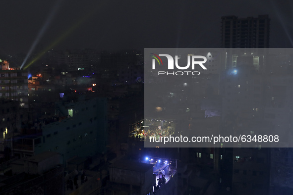 People set up party lights on a rooftop to celebrate Sakrain festival in Dhaka, Bangladesh on Thursday, January 14, 2021. 