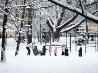 Small children are playin in a park covered with snow in Krakow, Poland. January 14, 2021.  (