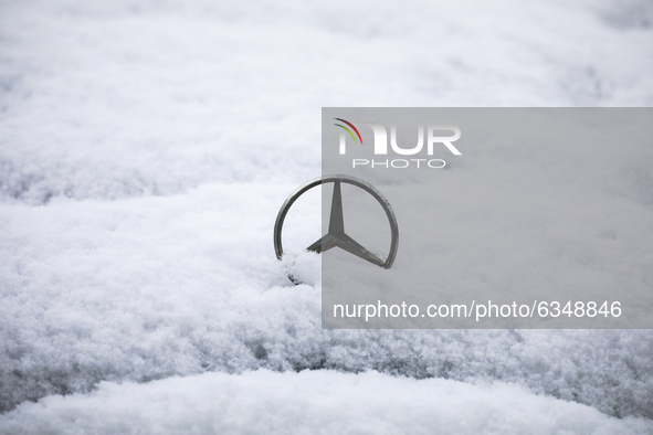 Mercedes Benz car emblem is covered with snow in Krakow, Poland. January 14, 2021.  