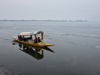 A  boatman rows his shikara carrying tourists in icy waters  inside t frozen Dal Lake, Srinagar, Indian Administered Kashmir on 14 January 2...
