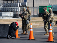 A President Donald Trump supporter wearing a MAGA hat is seen praying in front o Members  of The National Guard outside The US Congress. Was...