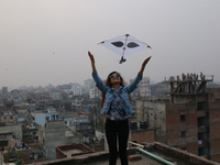 A girl flies kite as she celebrates Sakrain festival in Dhaka, Bangladesh on January 14, 2021. (