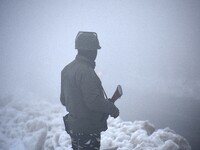 A paramilitary soldier stands on the main road amid dense fog in Srinagar, Kashmir on January 15, 2021.A meteorological department official...