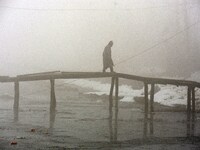 A man crossing a foot bridge amid dense fog in Srinagar, Kashmir on January 15, 2021.A meteorological department official said that Srinagar...